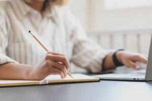 Una mujer tomando notas que lee en una notebook